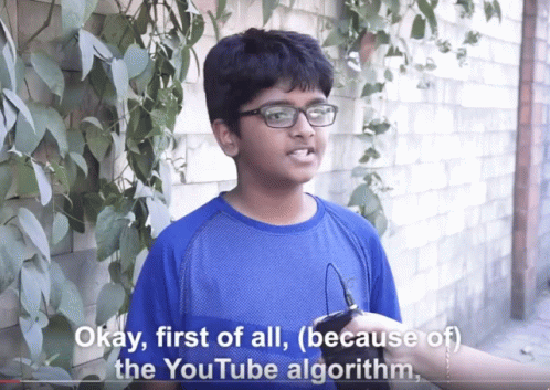 A Boy Wearing Glasses And A Blue Shirt Says Okay First Of All ( Because Of The Youtube Algorithm ) GIF