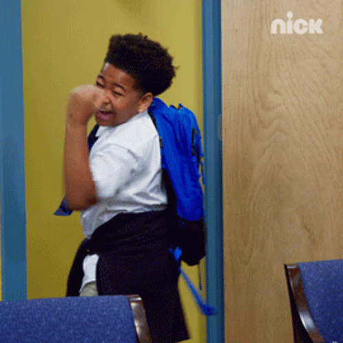 A Boy With A Blue Backpack Is Standing In Front Of A Door With The Nick Logo On It GIF