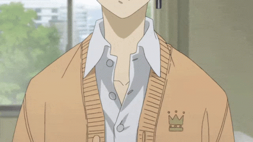 A Boy With A Cross Earring Is Wearing A Tan Sweater GIF