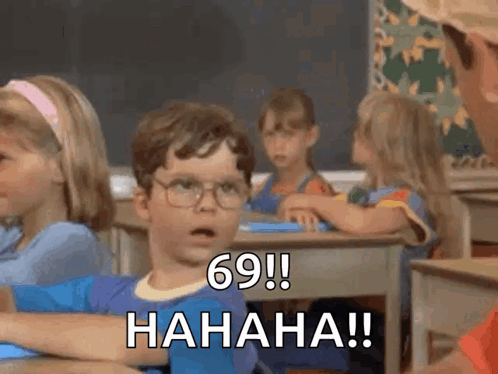 A Boy With Glasses Is Sitting At A Desk In A Classroom And Says 69 ! Hahaha !! GIF