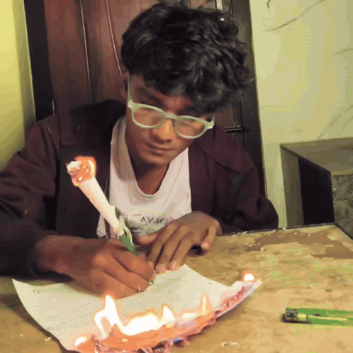 A Boy With Glasses Is Writing On A Piece Of Paper GIF