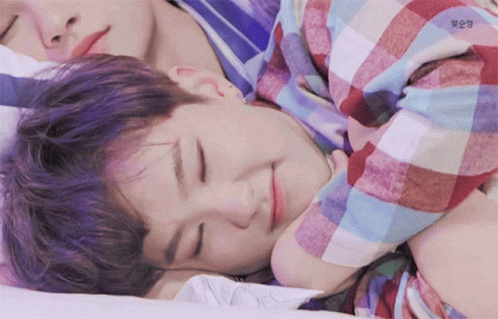 A Boy With Purple Hair Is Sleeping On Another Boy 'S Chest GIF