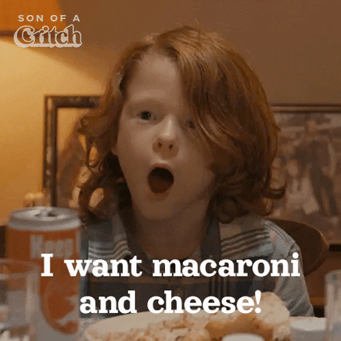 A Boy With Red Hair Is Sitting At A Table With His Mouth Open And Says " I Want Macaroni And Cheese " GIF
