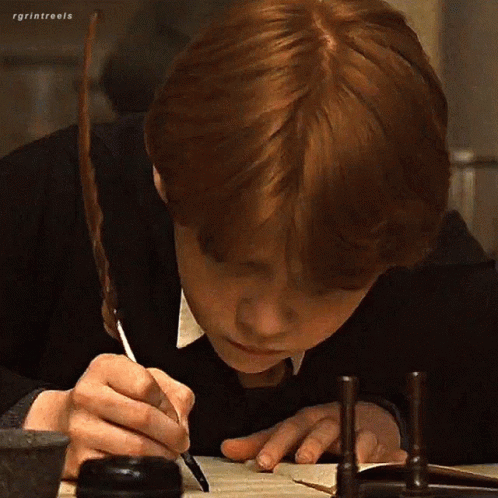 A Boy With Red Hair Is Writing On A Piece Of Paper With A Pen . GIF