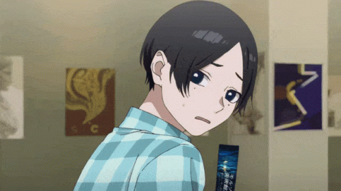A Boy With Short Black Hair Is Looking Over His Shoulder In A Room With Posters On The Wall GIF