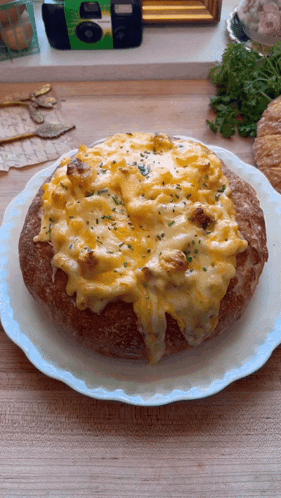 A Bread Bowl Filled With Macaroni And Cheese Is On A Plate GIF