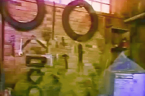 A Brick Wall With A Bunch Of Tools And Tires GIF