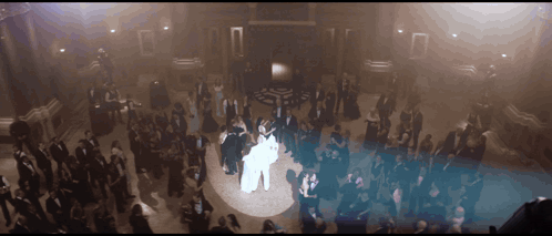 A Bride And Groom Are Dancing In Front Of A Large Crowd GIF