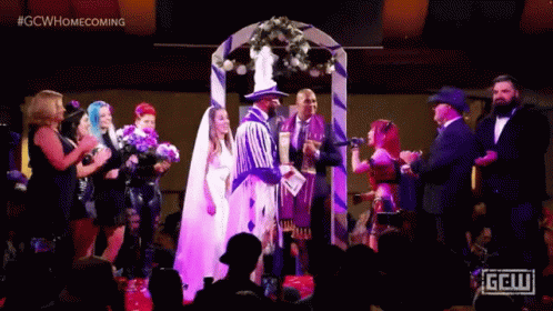 A Bride And Groom Are Getting Married In Front Of A Crowd At A Wedding . GIF