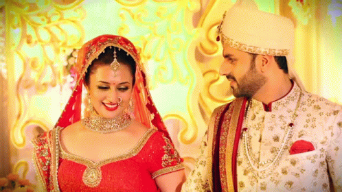 A Bride And Groom Are Posing For A Picture In Their Wedding Outfits GIF