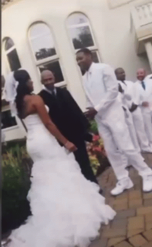A Bride And Groom Are Posing For A Picture With Their Wedding Party GIF