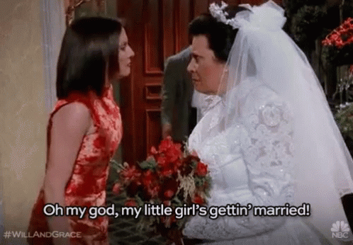 A Bride And Groom Are Standing Next To Each Other And The Bride Is Holding A Bouquet Of Flowers . GIF