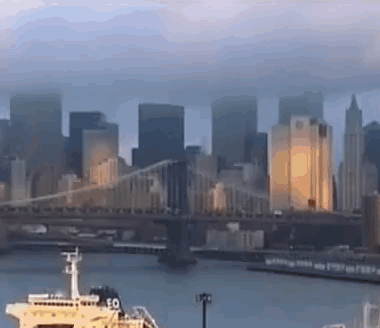 A Bridge Over A Body Of Water With A Boat In The Foreground GIF