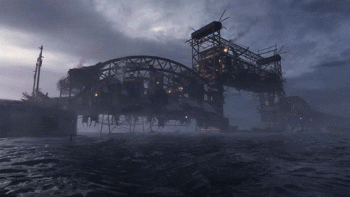 A Bridge Over A Body Of Water With A Dark Sky In The Background GIF