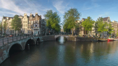 A Bridge Over A River Surrounded By Buildings GIF