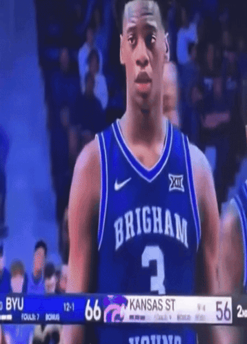 A Brigham Basketball Player Stands In Front Of A Scoreboard GIF