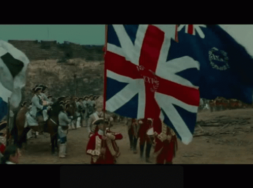 A British Flag Is Being Held By A Man In A Red Coat GIF