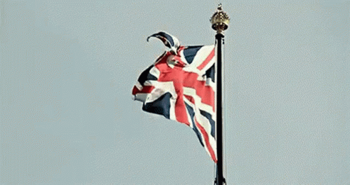 A British Flag Is Waving In The Wind On A Flag Pole . GIF
