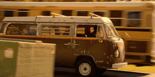 A Brown Van Is Parked In Front Of A Yellow School Bus GIF