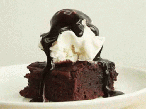 A Brownie With Ice Cream And Chocolate Sauce On Top Of It GIF