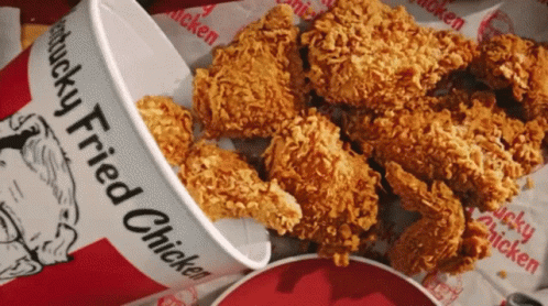 A Bucket Of Kfc Fried Chicken Sits Next To A Pile Of Fried Chicken GIF