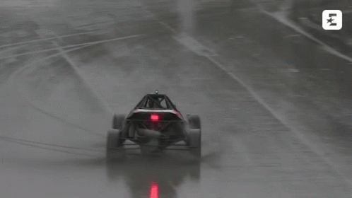 a buggy is driving on a wet track with the letters lk on the bottom left
