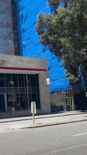 A Building With A Sign That Says No Parking On The Side Of It GIF