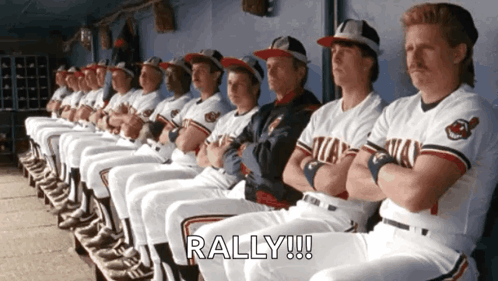 A Bunch Of Baseball Players Are Sitting In A Dugout And The Word Rally Is On The Bottom Right GIF