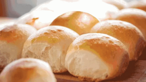 A Bunch Of Bread Rolls Sitting On A Table GIF