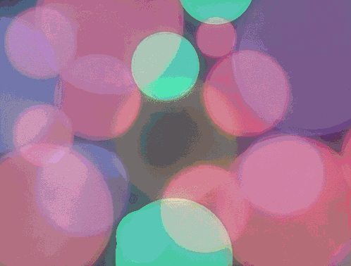 A Bunch Of Bubbles Are Floating In A Dark Room GIF