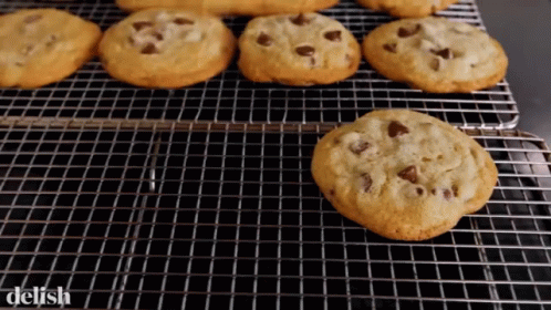 A Bunch Of Chocolate Chip Cookies On A Cooling Rack With The Word Delish On The Bottom GIF