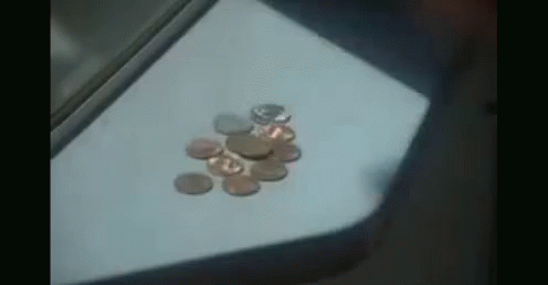 A Bunch Of Coins On A Table With One That Says ' A ' On It GIF