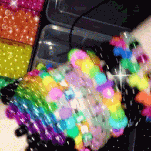 A Bunch Of Colorful Beads Are Stacked On Top Of Each Other On A Table GIF