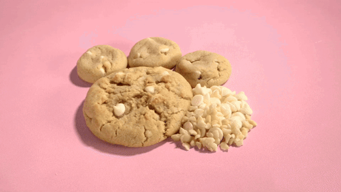 A Bunch Of Cookies On A Pink Surface GIF