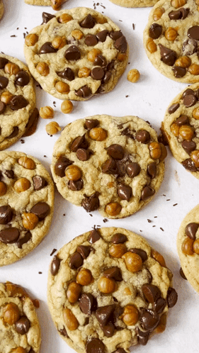 A Bunch Of Cookies With Chocolate Chips And Caramel Bits On Them GIF