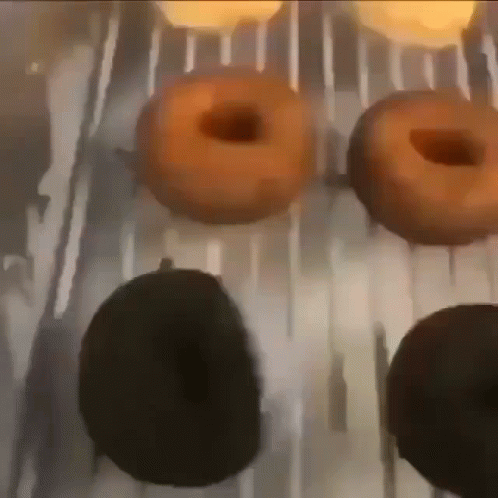 A Bunch Of Donuts Are Being Cooked On A Grill GIF
