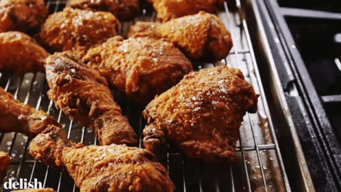 A Bunch Of Fried Chicken On A Rack With The Word Delish On The Bottom Right GIF