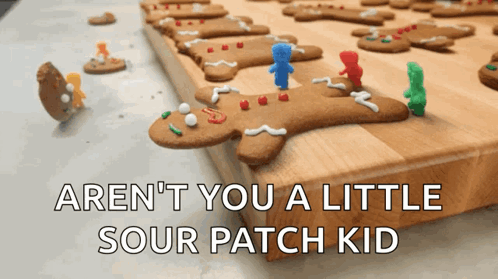 A Bunch Of Gingerbread Men On A Cutting Board With The Words Aren T You A Little Sour Patch Kid GIF
