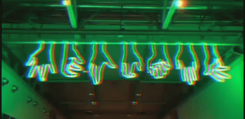 A Bunch Of Hands Are Hanging From The Ceiling In A Green Light GIF