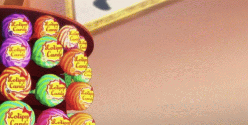 A Bunch Of Lollipops Are Lined Up On A Shelf GIF