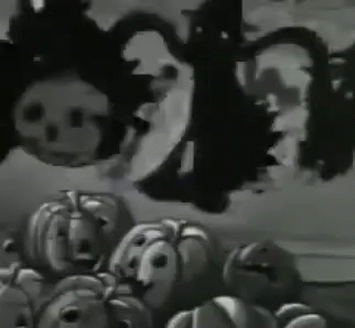 A Bunch Of Pumpkins With Faces On Them Are Sitting On A Table . GIF