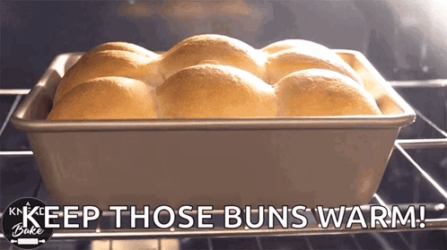 A Bunch Of Rolls In A Pan With The Words Keep Those Buns Warm Below Them GIF