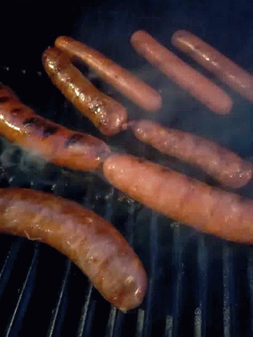 A Bunch Of Sausages Cooking On A Grill With Smoke Coming Out Of Them GIF