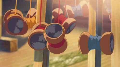 A Bunch Of Spools Of Thread Hanging From A Fence GIF