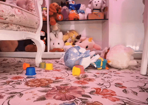 A Bunch Of Stuffed Animals Are On The Floor Including A Stuffed Unicorn GIF