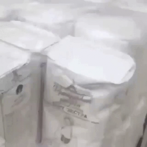 A Bunch Of White Boxes Are Sitting On A Table . GIF