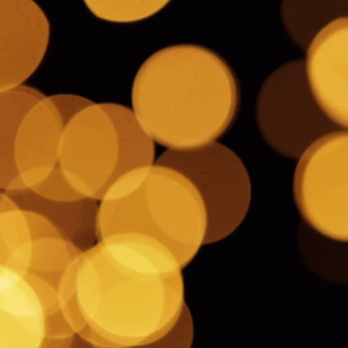 A Bunch Of Yellow Circles Are Floating In The Air GIF