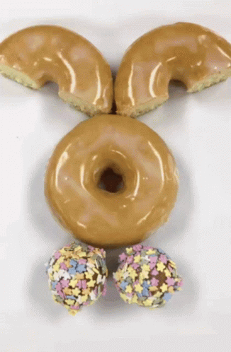 A Bunny Face Made Out Of Donuts And Sprinkles On A White Surface GIF