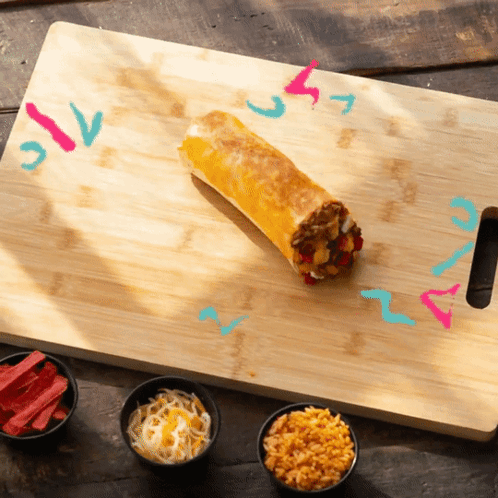 A Burrito Is Sitting On A Cutting Board Next To Bowls Of Various Toppings GIF