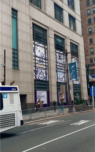 A Bus With The Number 8245 On The Back Is Parked In Front Of A Building GIF